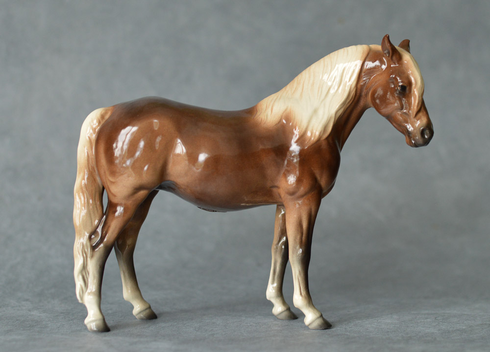 Standing ceramic horse figure with a rich brown coat, flaxen mane, and ears back