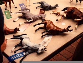Model horses on the table, some on their side, a mix of Hartlands, Breyers, and Hagen-Renakers, OF and custom
