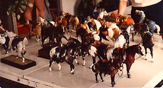 A table full of model horses wearing western tack