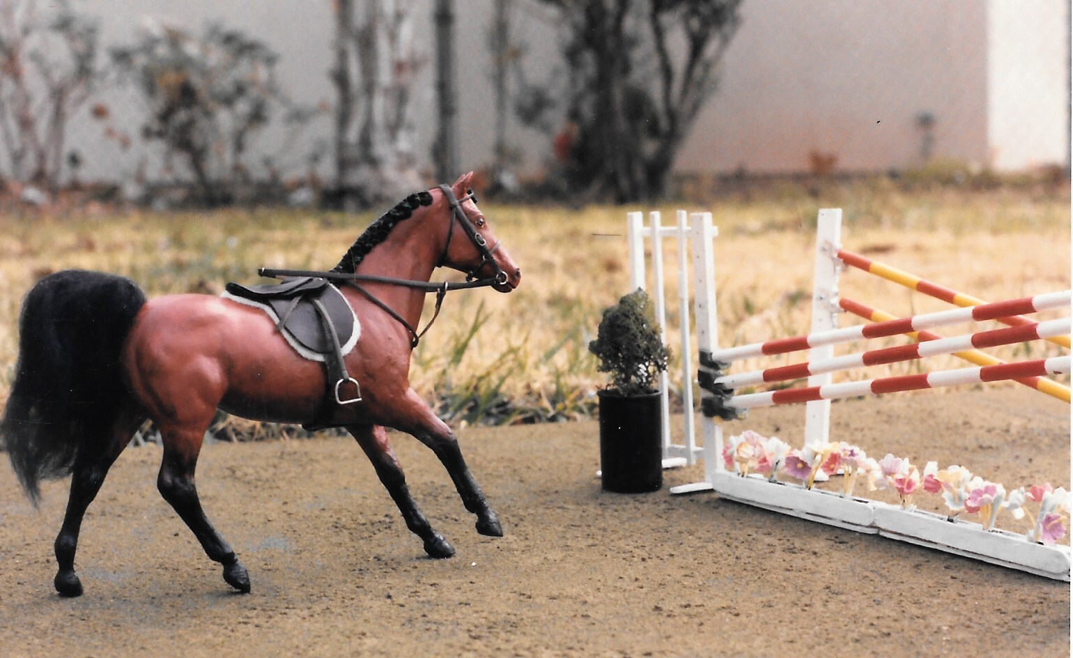 Ruffian customized into a canter, painted red bay with a poofy tail and braided mane, tacked up and heading for a swedish oxer.